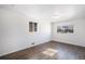 Bright bedroom featuring hardwood floors, white walls, and sunlit windows providing an open feel at 1654 Valentia St, Denver, CO 80220