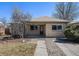 Charming single-story home with a brick facade, red door, landscaped yard, and a welcoming entrance at 1654 Valentia St, Denver, CO 80220