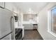 Bright kitchen with stainless appliances, gray cabinets, white countertops, dark floors, and a window at 1654 Valentia St, Denver, CO 80220