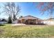 Spacious backyard with a covered patio, lush lawn, and mature trees, ideal for outdoor living at 2424 S Jasmine St, Denver, CO 80222