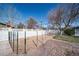 Backyard fenced in with wire and white fencing, with a small, graveled area to the side at 2424 S Jasmine St, Denver, CO 80222