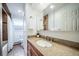 Well-lit bathroom featuring granite counters, a vanity, a bathtub, and a view into an adjacent toilet room at 2424 S Jasmine St, Denver, CO 80222