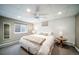 Basement bedroom with a large bed, egress window, neutral decor, and comfortable furniture at 2424 S Jasmine St, Denver, CO 80222
