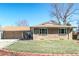 Charming brick house with a well-manicured front yard and mature trees, showcasing classic curb appeal at 2424 S Jasmine St, Denver, CO 80222