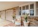 Charming brick front porch with white wicker chair and flower pots adding a touch of warmth to the home's entrance at 2424 S Jasmine St, Denver, CO 80222