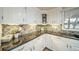 Updated kitchen features granite countertops, white cabinets, and decorative backsplash at 2424 S Jasmine St, Denver, CO 80222