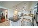 Well-lit kitchen boasts an island, modern appliances, and tiled floors at 2424 S Jasmine St, Denver, CO 80222