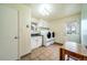 Well-lit laundry room with modern washer and dryer, functional cabinetry, and easy access to the backyard at 2424 S Jasmine St, Denver, CO 80222