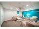 Living room with white and teal walls, carpet flooring, and decorative wicker furniture at 2424 S Jasmine St, Denver, CO 80222