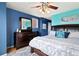 Cozy bedroom features colorful walls, a comfortable bed, wood dresser, and a ceiling fan at 476 S Saulsbury St, Lakewood, CO 80226