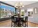 Bright dining room with large windows, a modern chandelier and a round wood table at 476 S Saulsbury St, Lakewood, CO 80226