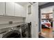 A laundry room with modern appliances and cabinets, leading to a bedroom at 476 S Saulsbury St, Lakewood, CO 80226