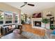 Inviting living room with a cozy fireplace, modern ceiling fan, and ample natural light from large windows at 476 S Saulsbury St, Lakewood, CO 80226
