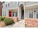 Exterior showcasing the entrances of multiple townhomes with brick accents and well-kept landscaping at 1150 Inca St # 25, Denver, CO 80204