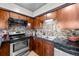 Functional kitchen with stainless steel appliances, dark countertops, and wood cabinetry at 1150 Inca St # 25, Denver, CO 80204