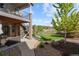 A beautiful backyard with a stone patio, a walkway, and green lawn, with an elevated porch at 1240 Starglow Pl, Highlands Ranch, CO 80126