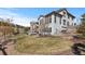 Beautifully landscaped backyard featuring a spacious lawn, mature trees, and a cozy outdoor seating area at 1240 Starglow Pl, Highlands Ranch, CO 80126