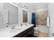 Bathroom featuring double sinks, dark cabinets and shower with curtain at 1240 Starglow Pl, Highlands Ranch, CO 80126