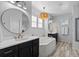 A spacious bathroom showcasing a soaking tub with white tile, dual sinks, and modern lighting at 1240 Starglow Pl, Highlands Ranch, CO 80126