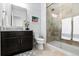 Well lit bathroom featuring a dark vanity and a glass shower with beige tiling at 1240 Starglow Pl, Highlands Ranch, CO 80126