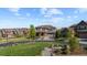 Beautifully landscaped front yard with lush green lawn, mature trees and a charming seating area at 1240 Starglow Pl, Highlands Ranch, CO 80126