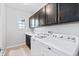 Laundry room with white washer and dryer, cabinets, and sink at 1240 Starglow Pl, Highlands Ranch, CO 80126