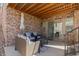 Covered patio with stone accents, comfortable seating, and an outdoor ceiling fan at 1240 Starglow Pl, Highlands Ranch, CO 80126