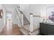 Elegant staircase with hardwood floors, white wainscoting, and a decorative area rug on the steps at 1240 Starglow Pl, Highlands Ranch, CO 80126
