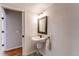 A charming bathroom with a pedestal sink, decorative mirror and wood look flooring at 5894 S Oak St, Littleton, CO 80127