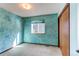 This bedroom boasts textured blue walls and a window providing natural light to the carpeted room at 5894 S Oak St, Littleton, CO 80127
