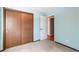 A quaint bedroom featuring light blue walls and a closet with natural wood sliding doors at 5894 S Oak St, Littleton, CO 80127