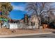 Well-maintained home features a brick chimney, manicured landscaping, and a white picket fence at 5894 S Oak St, Littleton, CO 80127