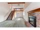 Inviting living room with a brick fireplace, wood trim, large windows, and an open staircase to the second story at 5894 S Oak St, Littleton, CO 80127