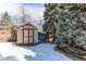 The home features a backyard storage shed and evergreen trees; the ground has partial snow cover at 5894 S Oak St, Littleton, CO 80127