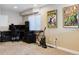 Basement room featuring a gaming setup, vintage comic artwork, and neutral carpet flooring at 24612 E Ontario Dr, Aurora, CO 80016