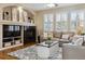 Comfortable living room featuring hardwood floors, a fireplace, and large windows with plantation shutters at 24612 E Ontario Dr, Aurora, CO 80016