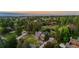 Scenic aerial view of home nestled among mature trees with a well-manicured lawn and charming curb appeal at 7398 E Windlawn Way, Parker, CO 80134