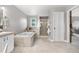 Large bathroom with soaking tub, shower, double vanity, and tile flooring creating a clean and luxurious space at 7398 E Windlawn Way, Parker, CO 80134