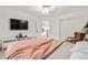 Bright bedroom featuring white walls, ceiling fan, television, and a cozy reading chair at 7398 E Windlawn Way, Parker, CO 80134