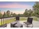 Outdoor deck boasts peaceful seating with views of lush trees and greenery at 7398 E Windlawn Way, Parker, CO 80134