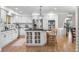 Kitchen features a large center island with seating, stainless steel appliances, and modern light fixtures at 7398 E Windlawn Way, Parker, CO 80134