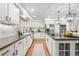 Light and airy kitchen with white cabinets, stainless appliances, and beautiful natural wood flooring at 7398 E Windlawn Way, Parker, CO 80134