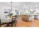 Open-concept kitchen and dining area with modern appliances, center island, and hardwood floors at 7398 E Windlawn Way, Parker, CO 80134