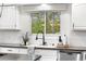The kitchen sink features a modern faucet, stainless steel appliances, and a serene view from the window at 7398 E Windlawn Way, Parker, CO 80134