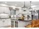 Bright kitchen features white cabinetry, stainless steel appliances, large windows and a center island at 7398 E Windlawn Way, Parker, CO 80134