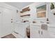 Bright and clean laundry room features a utility sink and wooden shelving creating a convenient and efficient space at 7398 E Windlawn Way, Parker, CO 80134