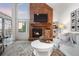 Bright living room features a fireplace with brick surround, large windows, and stylish decor at 7398 E Windlawn Way, Parker, CO 80134