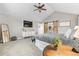 Bright primary bedroom with a barn door leading to the bath, gray walls, vaulted ceilings and large picture window at 7398 E Windlawn Way, Parker, CO 80134