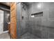Elegant walk-in shower with gray tile, built-in niche, and rain shower head at 7398 E Windlawn Way, Parker, CO 80134