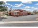 View of the brick townhomes, showing private garages and landscaping at 8424 Everett Way # A, Arvada, CO 80005